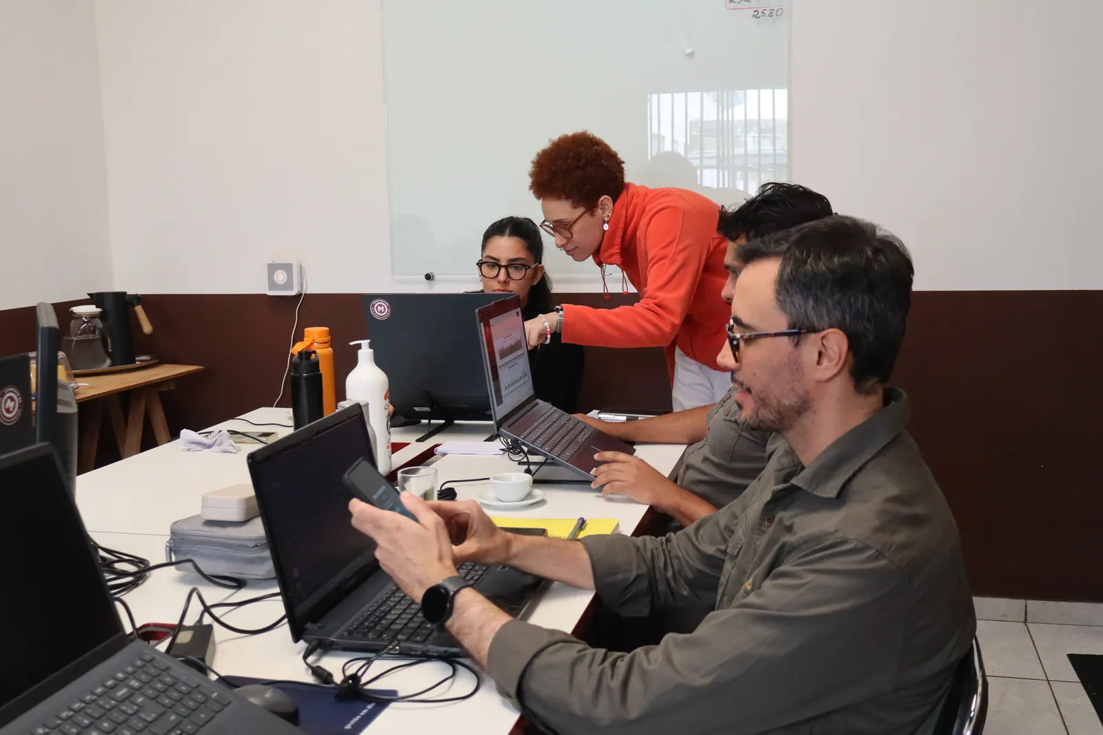 Equipe da Massalas trabalhando no escritório, com notebooks abertos sobre a mesa.